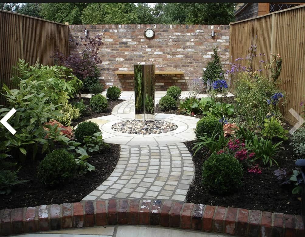 Circular feature garden with block paving and stainless steel water feature by Glorious Gardens Son & Co.