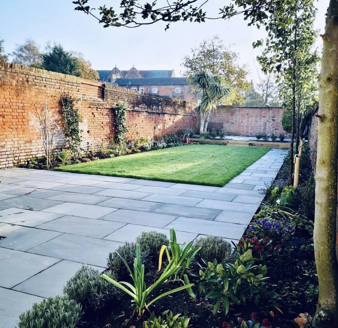 Large walled garden renovation with slate paving, lawn and border planting by Glorious Gardens Son & Co.
